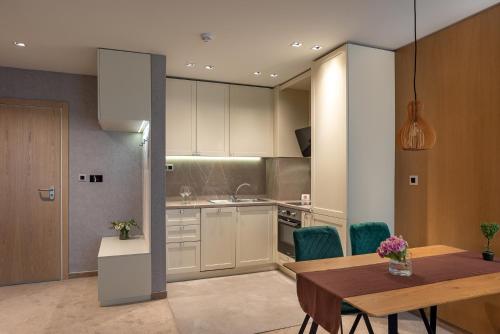 a kitchen with a table and a dining room at City Park Inn Apartment Verona in Plovdiv