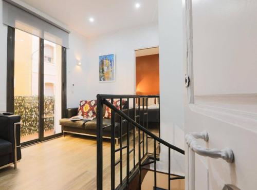 a living room with a couch and a staircase at New Listing DUPLEX NEAR THE BEACH Barceloneta in Barcelona