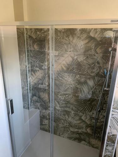 - une douche dans une chambre dotée d'un mur recouvert de plumes dans l'établissement La pauseto, à La Seyne-sur-Mer