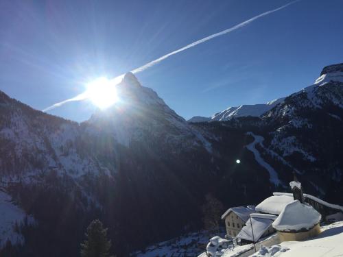 a view of a mountain with the sun shining on it at Fedaia Joy B&B in Canazei