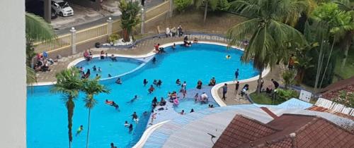een groep mensen in een groot zwembad bij Studio Beach View Teluk Kemang in Port Dickson