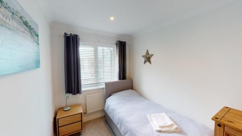 a small bedroom with a bed and a window at Rest Ashored in Exmouth