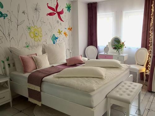 Ferienwohnung Kessler في روست: غرفة نوم مع سرير مع زهور على الحائط