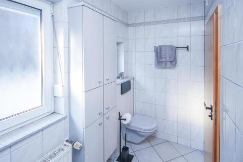 a white bathroom with a toilet and a window at ALFA Stuttgart 3Zi-Maisonette 6 Personen Zuffenhausen nahe Porsche & Bosch in Stuttgart