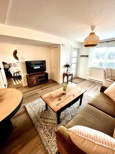 a living room with a couch and a coffee table at Cozy Lakeview Suite in Victoria