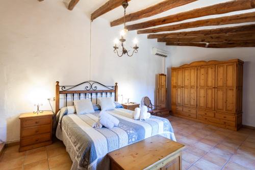a bedroom with a bed and a table and a chandelier at Villa with pool Can Tomeu in Es Capdellà in Capdellá