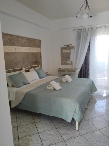 a bedroom with a large bed with two towels on it at Manganas Studios in Paleokastritsa
