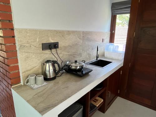 a kitchen counter with two pots and pans on it at Coastal Hideaway in Midigama