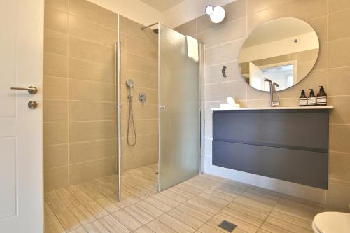 y baño con ducha y lavamanos. en Bat-Galim Beach Apartment, en Haifa