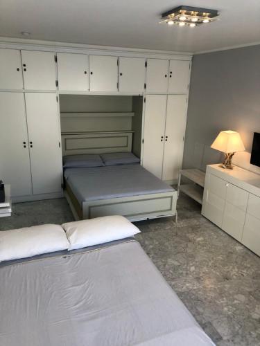 a bedroom with two beds and white cabinets at Residence Albert Premier in Menton
