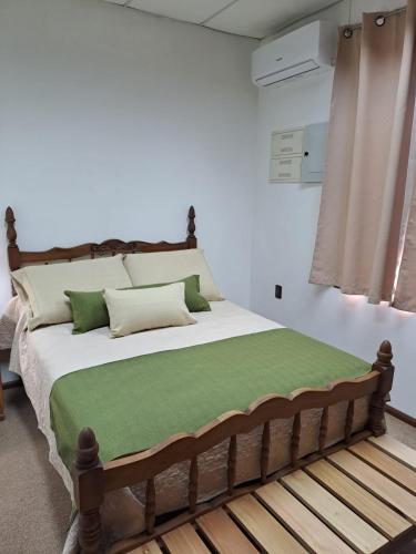 a bedroom with a large bed with a green blanket at Mykonos Centro Apartamento in Carmelo
