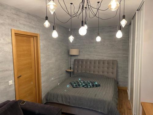 um quarto com uma cama e um lustre em Modern Apartment suitable for longstays em Riga