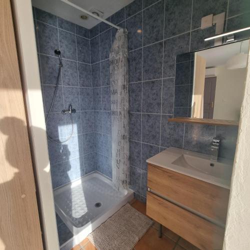 une salle de bain avec douche et lavabo dans l'établissement Chambre avec piscine partagée, à Marcorignan