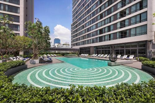 a swimming pool in the middle of a building at Bangkok Marriott Marquis Queens Park in Bangkok
