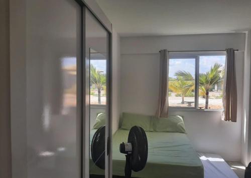 a bedroom with a bed with a mirror and a window at Apto PDI na praia em Baixio in Baixio