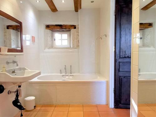 y baño con bañera y lavamanos. en l'Ecurie - La Maïsou en Sérignac