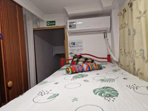 a bed in a room with a bedspread with plants on it at APARTAMENTO MADRID Norte in San Sebastián de los Reyes