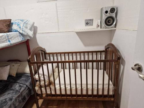 a crib in a room with a speaker on the wall at APARTAMENTO MADRID Norte in San Sebastián de los Reyes