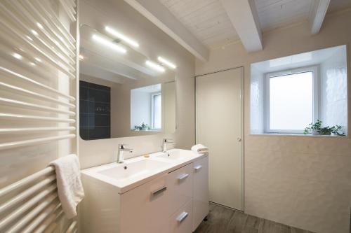 ein weißes Badezimmer mit einem Waschbecken und einem Spiegel in der Unterkunft AR PENNITI - Magnifique maison en pierre proche plage in Landéda