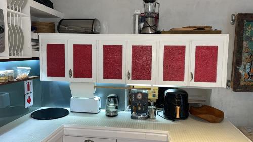 a kitchen counter with white cabinets and a coffee maker at Arbeidsgenot, Unit 2 in Herolds Bay