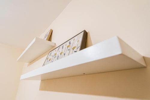 a shelf in a room with two books on it at Deluxe 2-Bedroom Flat with Free parking in Birmingham