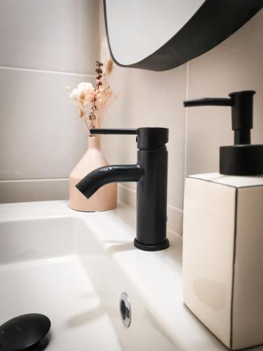 - un comptoir de cuisine avec un évier et un robinet dans l'établissement Appart Cozy - cœur historique de Moissac, à Moissac