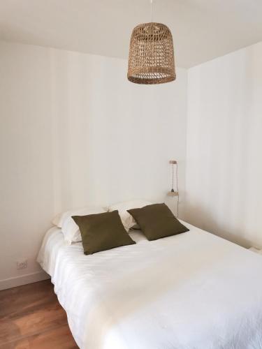 un lit blanc avec deux oreillers dessus dans l'établissement Appart Cozy - cœur historique de Moissac, à Moissac