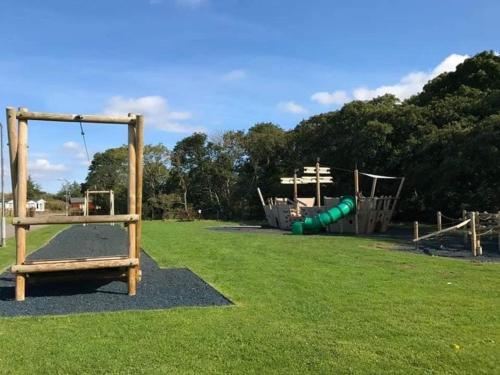 a park with a playground with a slide at Lemon Tree Lodge in Morpeth