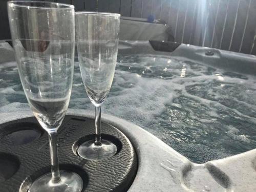 two champagne glasses sitting in a hot tub at Lemon Tree Lodge in Morpeth