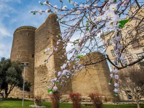 a building with two nuclear towers with flowering trees at Dondar Hotel Formula 1 View in Baku
