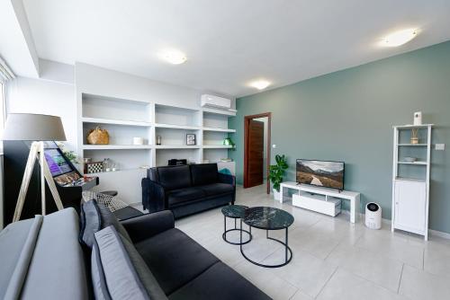 un soggiorno con divano e tavolo di Patras' Hitech Apartment a Patra