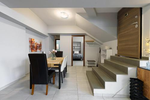 a kitchen and dining room with a dining table and stairs at Patras' Hitech Apartment in Patra