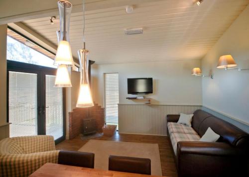 ein Wohnzimmer mit einem Sofa und einem TV in der Unterkunft The Sherwood Hideaway Lodges 
