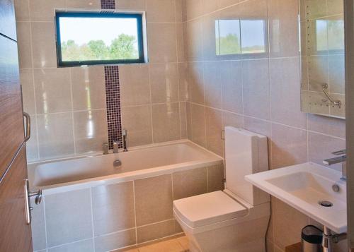 ein Badezimmer mit einer Badewanne, einem WC und einem Waschbecken in der Unterkunft The Sherwood Hideaway Lodges 