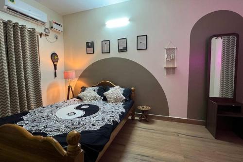 ein Schlafzimmer mit einem Bett mit einer großen Bettdecke mit einem Gesicht darauf in der Unterkunft Wind and Wave Villa No 2, 2BHK Near Pondy Auroville Pondicherry in Marakkānam