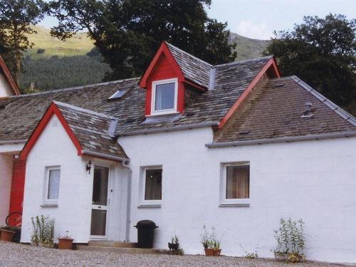 une maison blanche avec un toit rouge dans l'établissement Inverardran House Bed and Breakfast, à Crianlarich