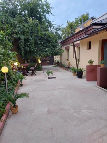 a courtyard with benches and tables and trees at Ambiennt in Bucharest