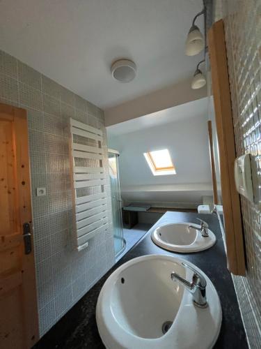 a bathroom with two sinks and a shower at Moulin D’Huile in Chaumard
