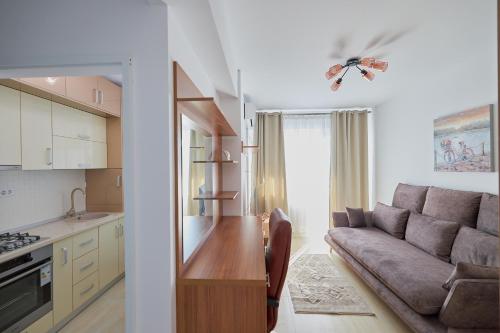 Il comprend une cuisine et un salon avec un canapé. dans l'établissement Alessandro Home 5 Luxury Centru Palas Mall Iași Q Residence, à Iaşi