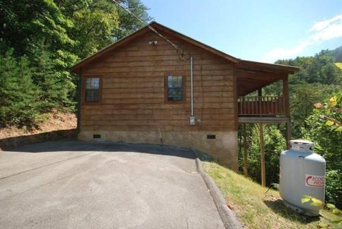 ein Blockhaus mit einem Mülleimer davor in der Unterkunft Little Cabin All To Yourself in Sevierville