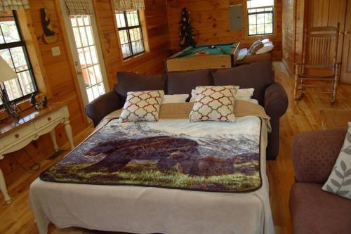 a bedroom with a bed with a blanket on it at Little Cabin All To Yourself in Sevierville