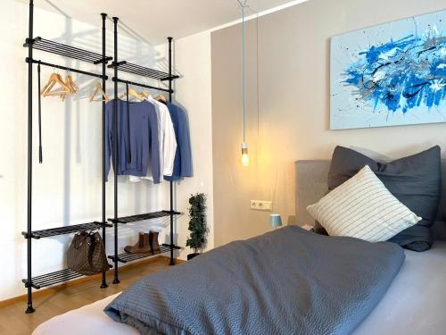 a bedroom with a clothes rack and a bed at Louise's City Apartment an der Uferpromenade in Friedrichshafen