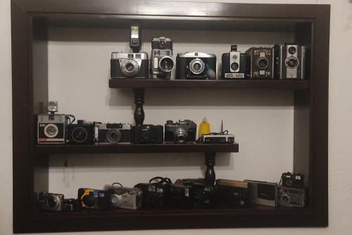 a shelf with several cameras and other cameras on it at Hospedaje La Lomita in Monguí