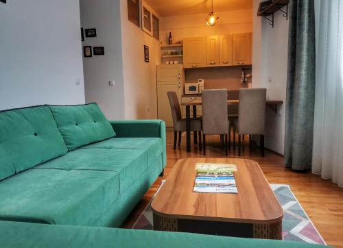 sala de estar con sofá verde y mesa en Apartment Mademoiselle, en Višegrad