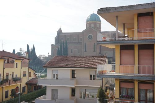 un bâtiment avec une tour d'horloge et une église dans l'établissement Domus Anna, à Montegrotto Terme