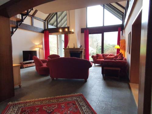 ein Wohnzimmer mit roten Sofas und einem TV in der Unterkunft Großes Ferienhaus Sauerburgblick in Sauerthal
