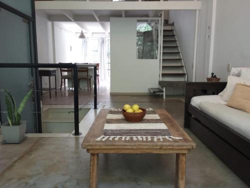 una sala de estar con una mesa con un bol de fruta. en Unique Loft with Wi-Fi & Netflix en Buenos Aires