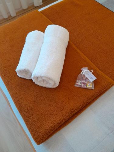 dwie rolki papierowych ręczników na pomarańczowym ręczniku w obiekcie Apartment Dean w mieście Klimno
