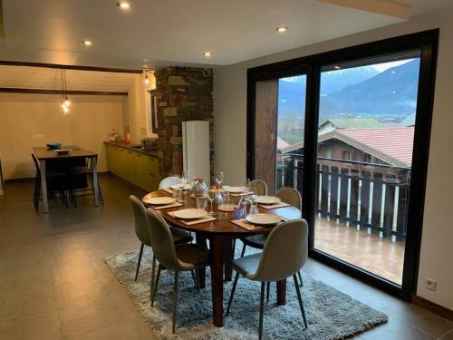 a dining room with a table with chairs and a large window at Duplex 3 chambres Vue Mont-Blanc in Domancy