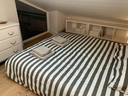 a bedroom with a striped bed with two towels on it at Duplex 3 chambres Vue Mont-Blanc in Domancy